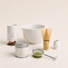 NOA Matcha complete organic set — ceremonial matcha tin, ceramic bowl, bamboo whisk, holder and sifter on a cream background